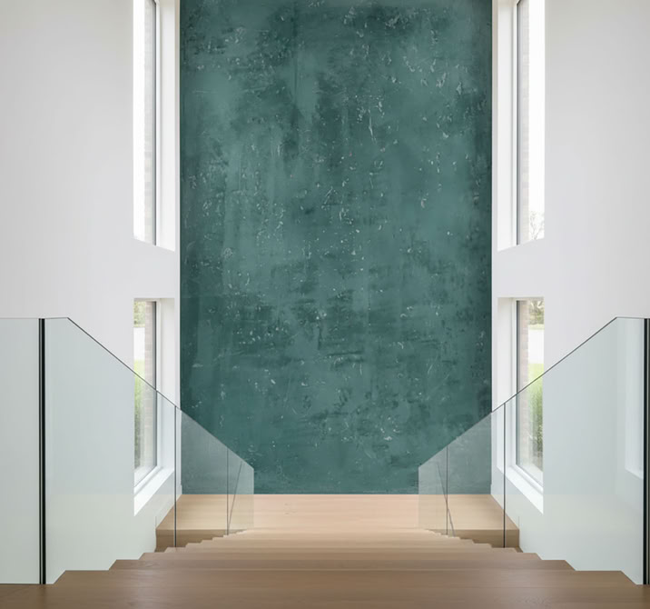 Moderner Innenraum mit einer Treppe, die von Glasgeländern flankiert wird, und einer großen Wand mit W 137 Classic hohe Wand im Treppenhaus