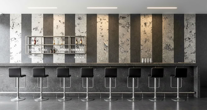 Eine moderne Bar mit neun schwarzen Barhockern vor einer Wand mit vertikalen Streifen mit glaMUR Effektspachtel