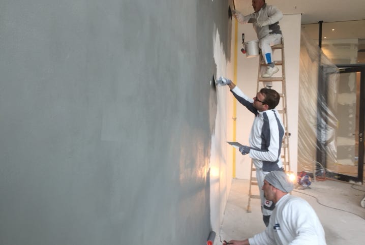 Handwerker verputzen eine Wandbeschichtung von glaMUR