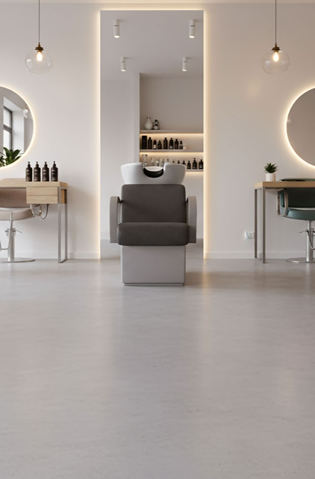 Ein moderner Friseursalon mit Fugenlosen Boden mit Rexx 2K , runden Spiegeln an der Wand, hängenden Lampen und Pflanzen.