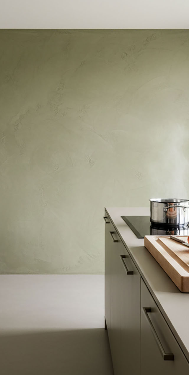 Hintergrund ist eine oliv grüne Wand mit Paterra zu sehen.