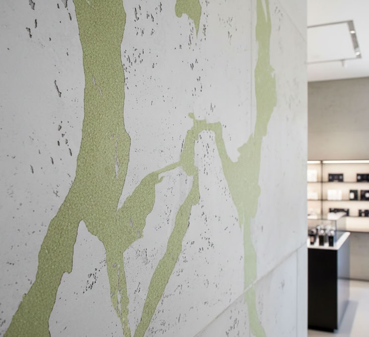 Grüne abstrakte Muster auf einer Beton Style Wand in den Farbtoenen 901, 922 